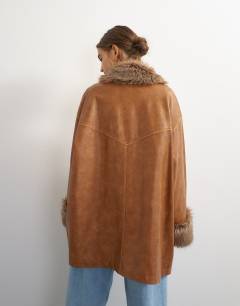 Model wearing Faux leather jacket with faux fur trim in tan