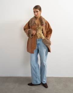 Model wearing Faux leather jacket with faux fur trim in tan