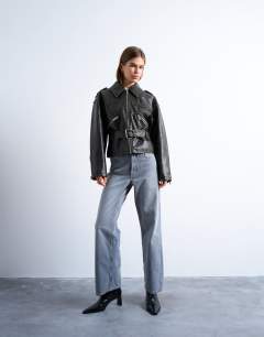 Model wearing Faux leather low belted biker jacket in washed black
