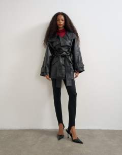 Model wearing Faux leather mid length belted jacket in black