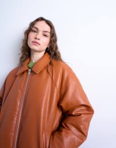Model wearing Faux leather padded puffer jacket in burnt orange