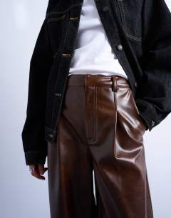 Model wearing Faux leather pleated straight leg trouser in rust