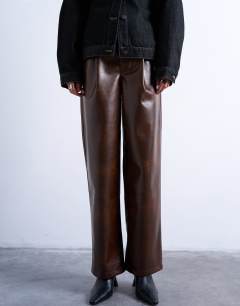 Model wearing Faux leather pleated straight leg trouser in rust
