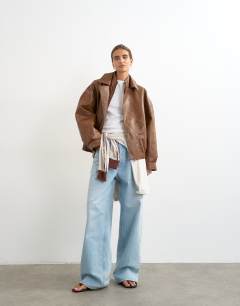 Model wearing Faux leather seam detail bomber jacket in tan