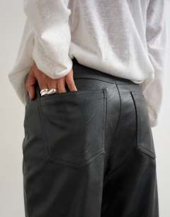Model wearing Faux leather straight leg trousers in black
