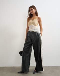 Model wearing Faux leather stripe wide leg trousers in black