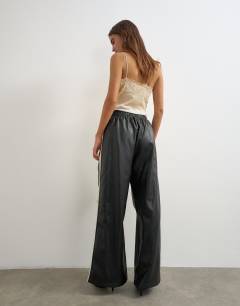 Model wearing Faux leather stripe wide leg trousers in black