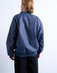 Model wearing Faux leather washed MA1 bomber jacket in denim blue
