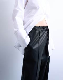 Model wearing Faux leather wide leg jogger with pinseam detail in black