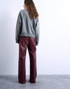 Model wearing Faux leather wide leg jogger with pinseam detail in burgundy