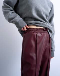 Model wearing Faux leather wide leg jogger with pinseam detail in burgundy