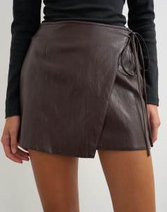 Model wearing Faux leather wrap tie detail mini skirt in chocolate