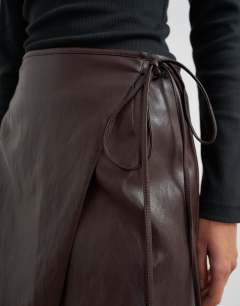 Model wearing Faux leather wrap tie detail mini skirt in chocolate