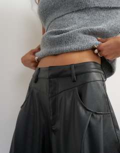 Model wearing Faux leather yoke detail barrel leg in black