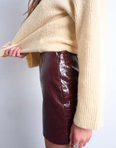 Model wearing Faux snake patent leather mini skirt in burgundy