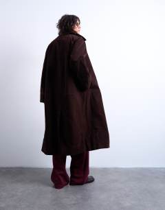 Model wearing Faux suede funnel long car coat with neck tab in brown