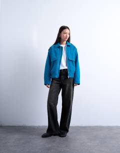 Model wearing Faux suede quilted lined bomber jacket with popper details in bright blue