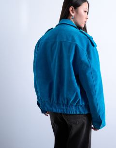 Model wearing Faux suede quilted lined bomber jacket with popper details in bright blue