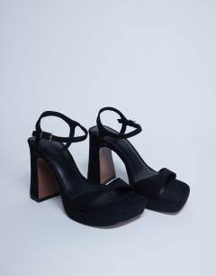 Model wearing Faye chunky platform heeled sandal in black 