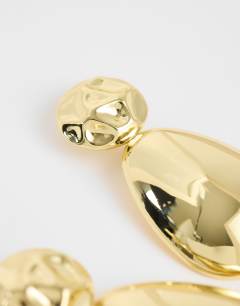Model wearing Faye stud drop earrings in gold
