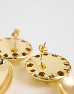Model wearing Faye stud drop earrings in gold