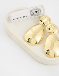 Model wearing Faye stud drop earrings in gold