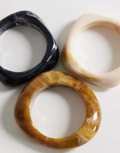 Model wearing Ferdy 3 pack resin bangles in tiger, off white and black