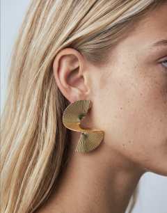 Model wearing Fergy folded detail earring in gold