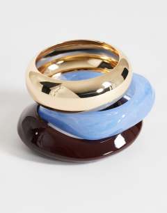 Model wearing Finn 3 pack resin bangles in gold, blue and brown