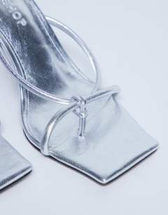 Model wearing Flora strappy toe loop high heel in silver