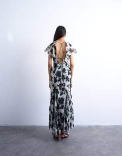 Model wearing Flutter sleeve godet hem midi dress in mono print