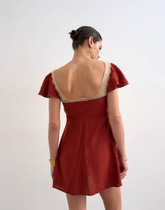 Model wearing Flutter sleeve mini tea dress with lace inserts in rust
