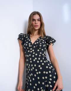 Model wearing Flutter sleeve v neck midi dress in mono spot