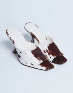 Model wearing Fox real leather pony heeled mule in cow print 