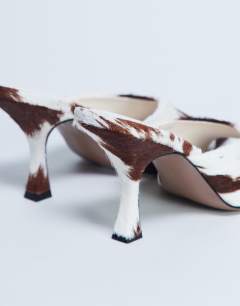Model wearing Fox real leather pony heeled mule in cow print 