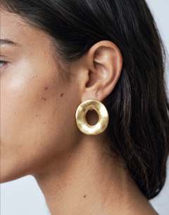 Model wearing Francis waterproof stainless steel round earrings in gold brushed