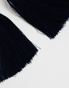 Model wearing Franklin hoop tassel earrings in navy