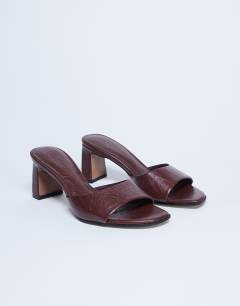 Model wearing Freya heeled mule in burgundy