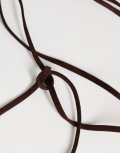 Model wearing Fringe cord suedette belt in chocolate
