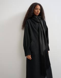 Model wearing Fringe detail belted longline coat with wool in black