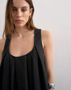 Model wearing Full hem pleated mini sundress in black