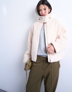 Model wearing Funnel boucle tab detail bomber in cream