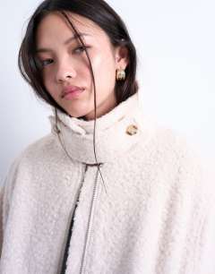 Model wearing Funnel boucle tab detail bomber in cream
