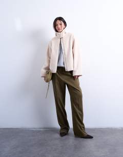 Model wearing Funnel boucle tab detail bomber in cream