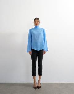Model wearing Funnel neck backwards long sleeve shirt in cornflour blue