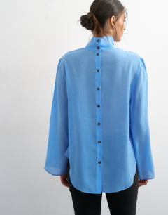 Model wearing Funnel neck backwards long sleeve shirt in cornflour blue