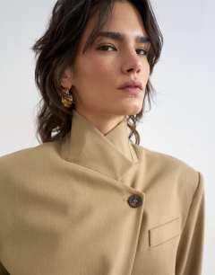 Model wearing Funnel neck blazer in stone