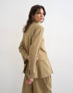 Model wearing Funnel neck blazer in stone