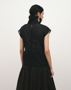 Model wearing Funnel neck sheer organza top in black