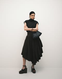 Model wearing Funnel neck sheer organza top in black